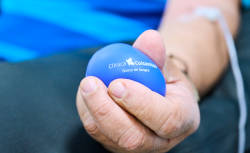 En un primer plano se ve una mano apretando una pelota antiestrés con el logo de Clínica Colsanitas.