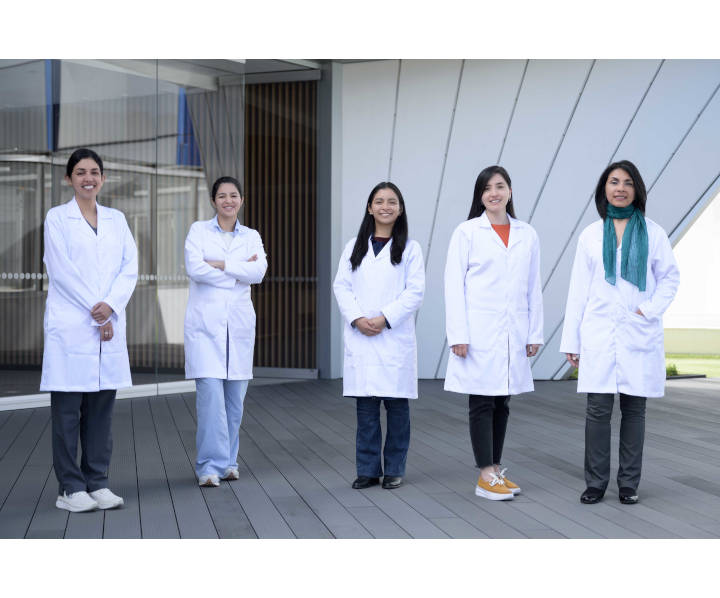 Se observan 5 profesionales de la salud de pie sonriendo frente a la cámara.